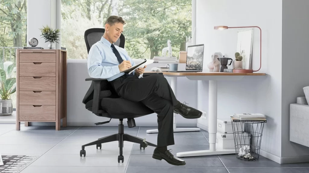 man sitting in ergonomic office chair at desk
