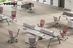 In an open plan office environment, pink SM6 Ergonomics office chairs fill the staff space