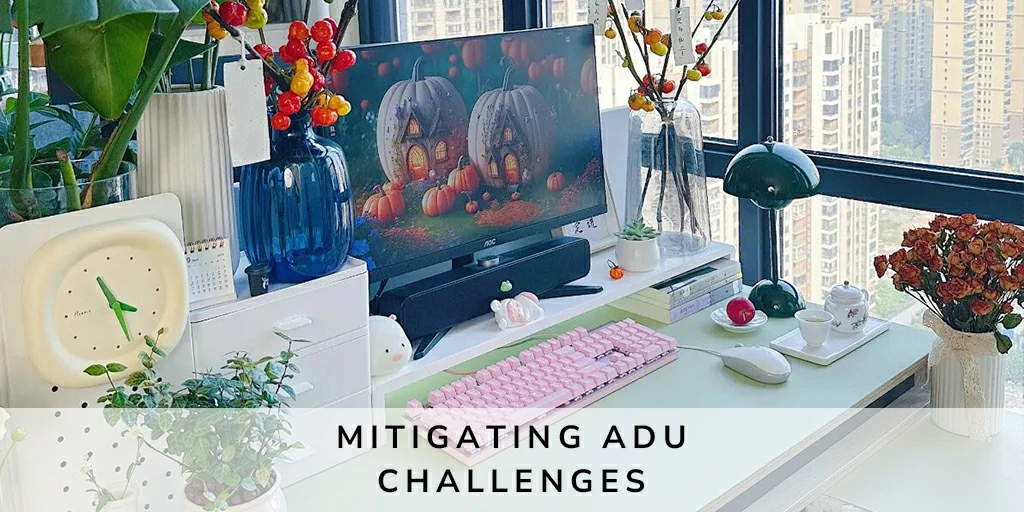 Bright and stylish home office setup inside an Accessory Dwelling Unit, with a city view, featuring a decorative vase, colorful autumn-themed desktop wallpaper, and an organized desk space with books, a classic lamp, and vibrant plants, symbolizing overcoming ADU space challenges.